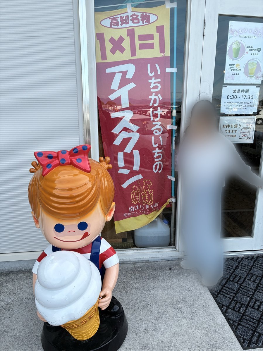 店舗の入り口に設置された、アイスクリームを持った可愛らしいキャラクターの像。店内には「高知名物 アイスクリン」のポスターが見える。