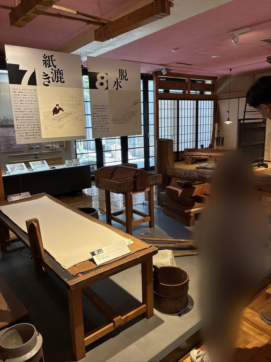 紙の製造工程を説明する大きな図解パネルや、紙漉きに使われる木製の道具が展示された広々とした空間。