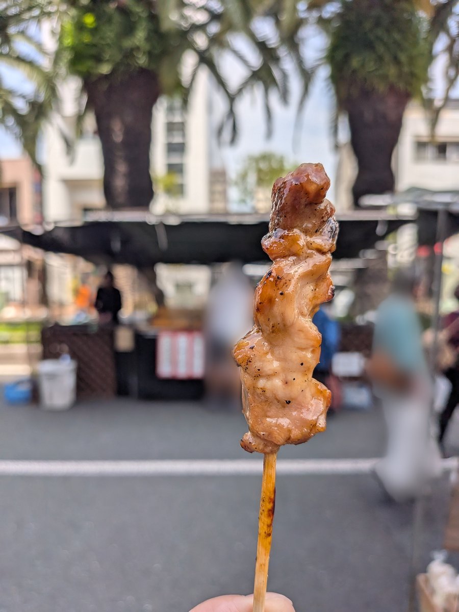 香ばしいタレが絡んだ焼き鳥の串をアップで捉えた一枚。食べ歩きにぴったり。