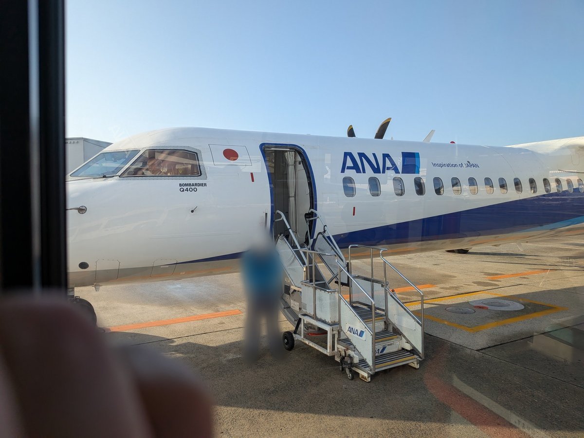 空港ターミナルビルの中からガラス越しに見た、ANAのプロペラ機「ボンバルディアQ400」。搭乗口付近の様子。