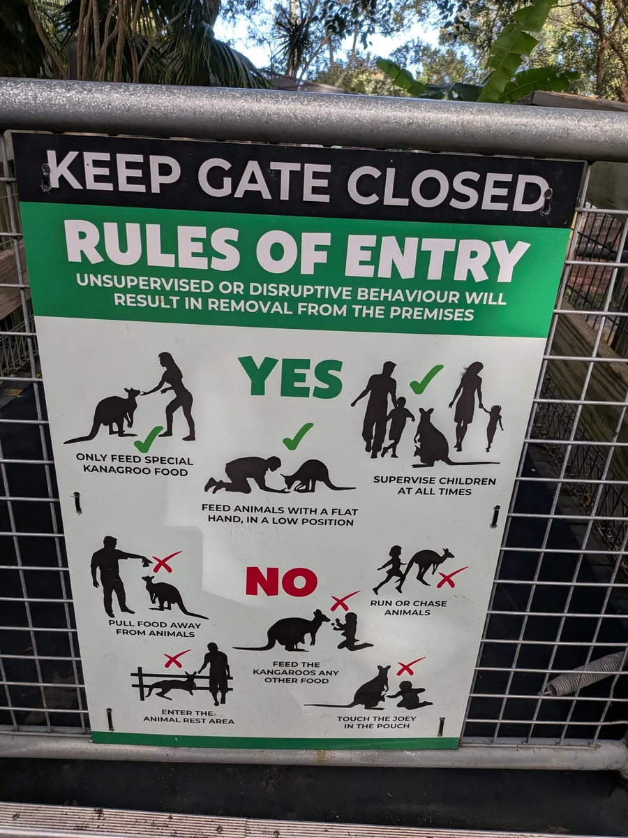 餌やりエリア入口の「RULES OF ENTRY」看板。手を平らにして低い位置で与える、追いかけない、休憩エリアに入らないなどがイラストで示されている