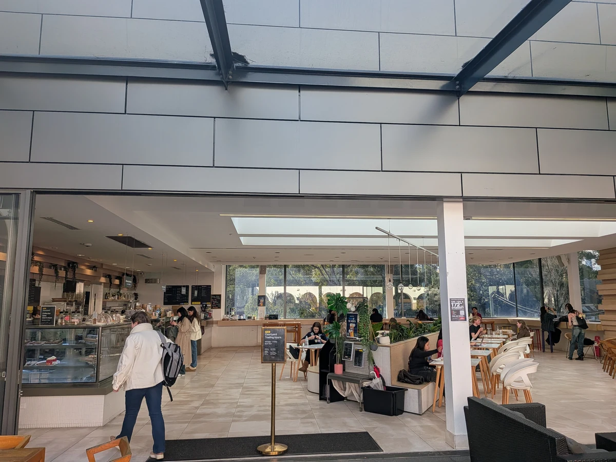 Courtyardの屋内カフェ側。ガラス張りの明るい空間にカウンターとテーブル席が並び、天井から自然光が入っている