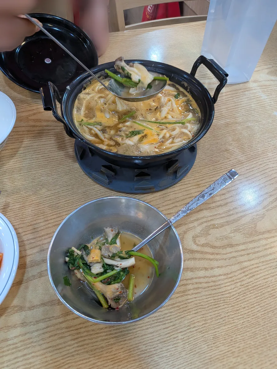 名物きのこカルグクスの鍋。きのこたっぷりの澄んだスープ