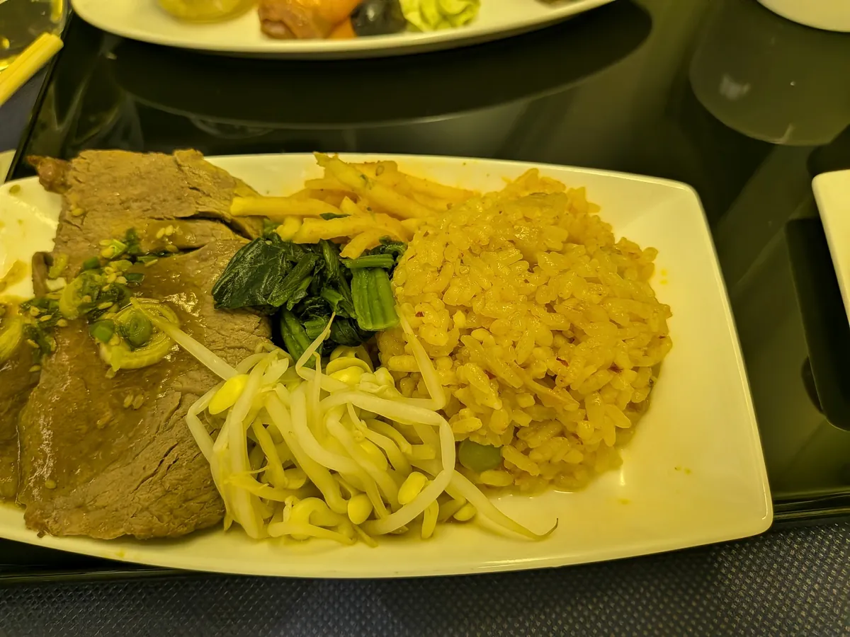 ビジネスクラスのメイン。牛肉とカレー風味のライス、もやしと青菜