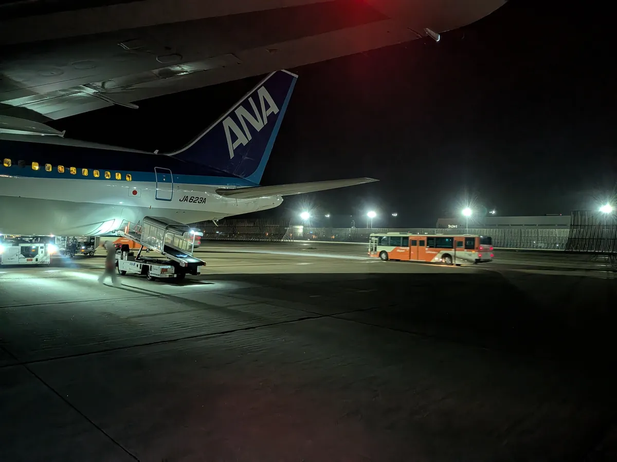 夜の駐機場に佇むANA機。沖止めでランプバスから搭乗