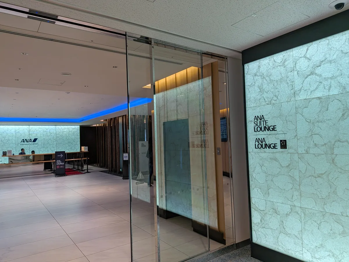 ANA SUITE LOUNGE と ANA LOUNGE のガラス張りの入口（大理石調のサイン）