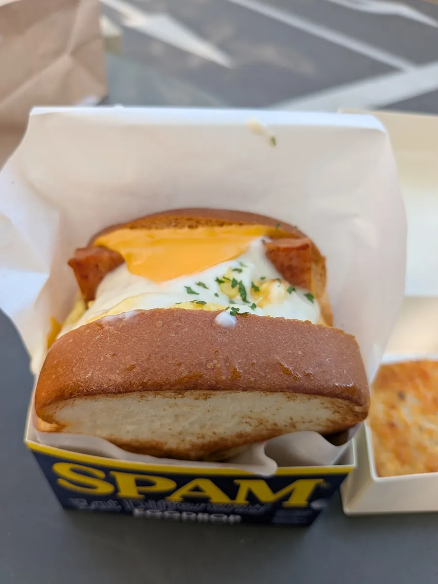 とろけるチーズと半熟卵、スパムが入ったエッグサンドのアップ