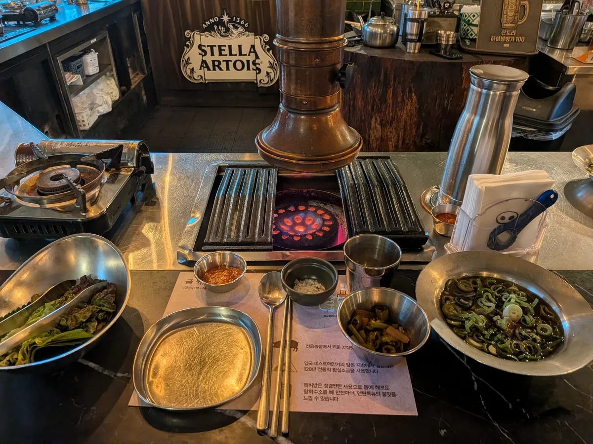 焼肉のテーブルセット。グリルとおかず、ビール