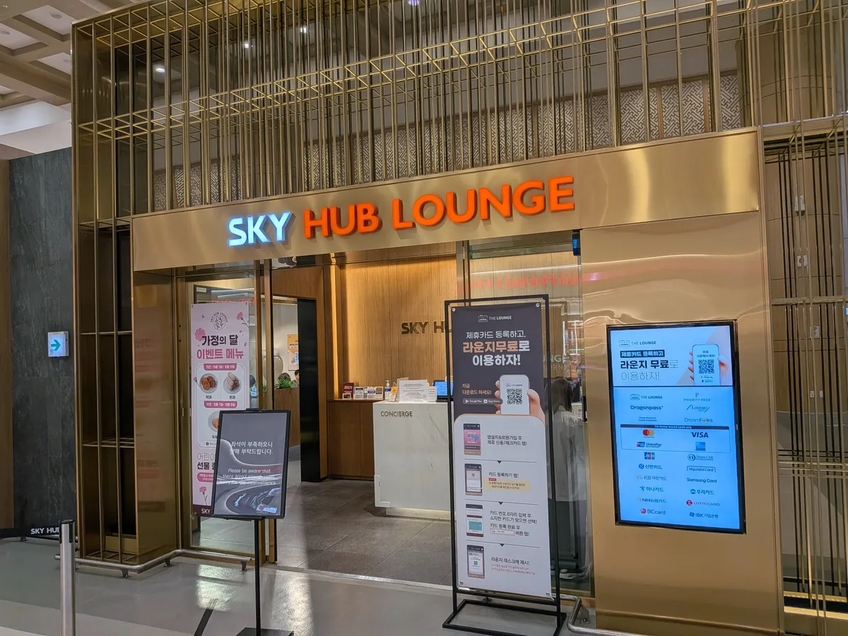スカイハブラウンジ（SKY HUB LOUNGE）の入口。金色のゲートとコンシェルジュ