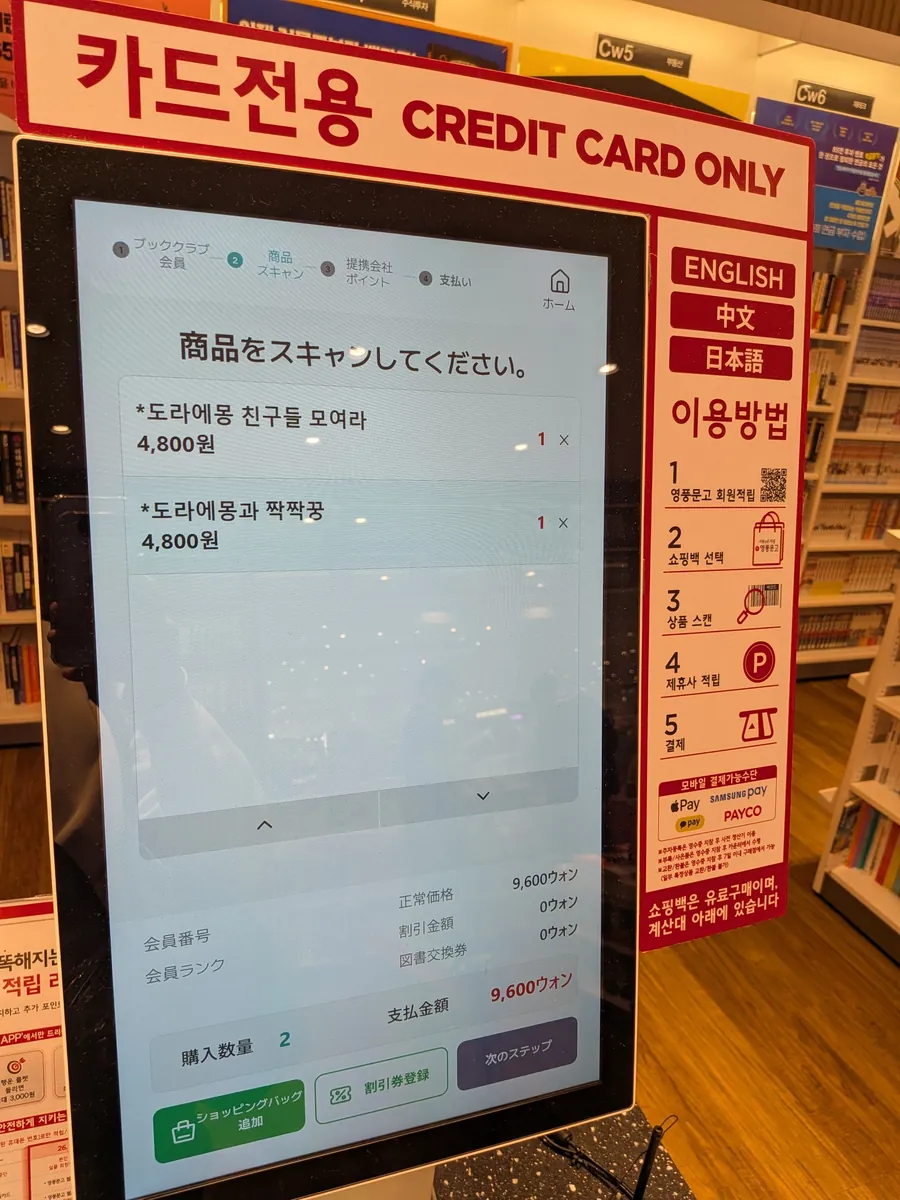 書店のセルフレジ画面。カード専用・日本語対応でドラえもんの立体シールを会計