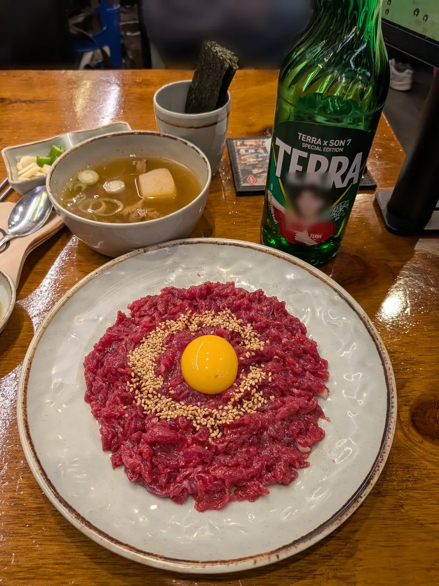 卵黄をのせた名物ユッケと、TERRAの瓶ビール