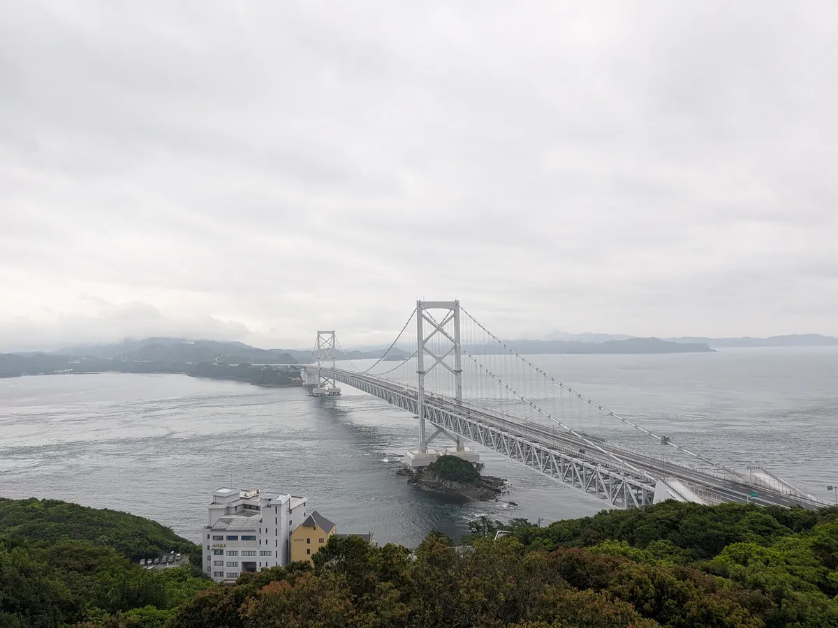 鳴門山展望台から見下ろす大鳴門橋と鳴門海峡。曇り空の下に架かる白い吊り橋