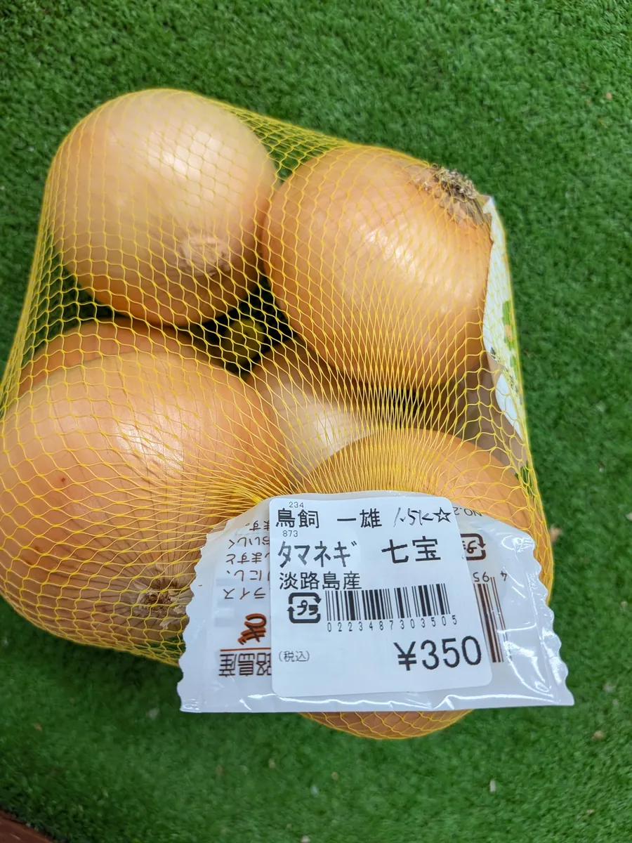 ネット袋入りの新玉ねぎ。値札は350円