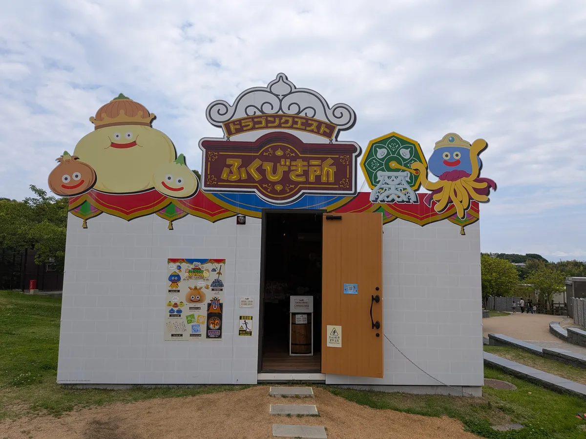 ドラゴンクエストアイランドのふくびき所。スライムなどのキャラクター看板が飾られた白い建物