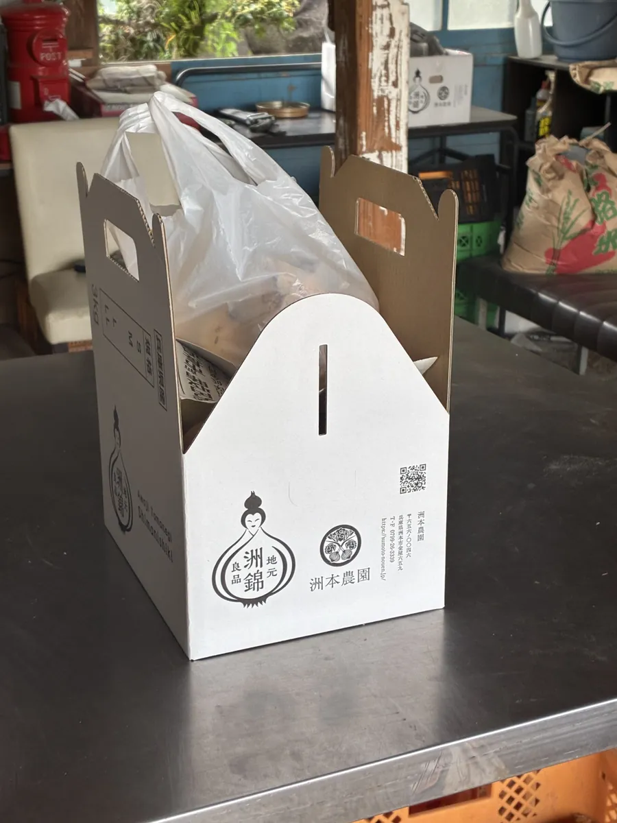 「洲本農園・洲錦」のロゴ入り3kgの手提げ箱に入れてもらった新玉ねぎ