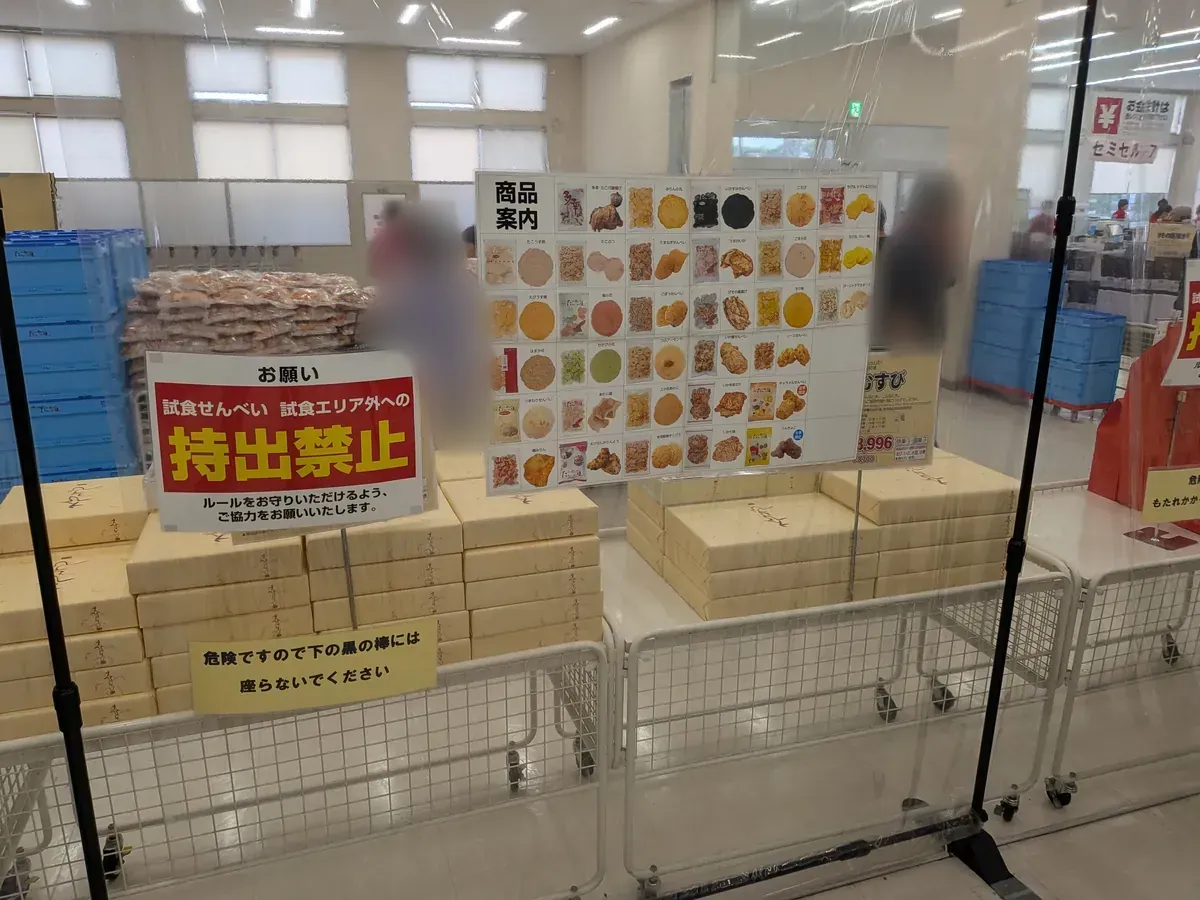試食せんべいの持出禁止の掲示と、全商品の写真入り商品案内ボード