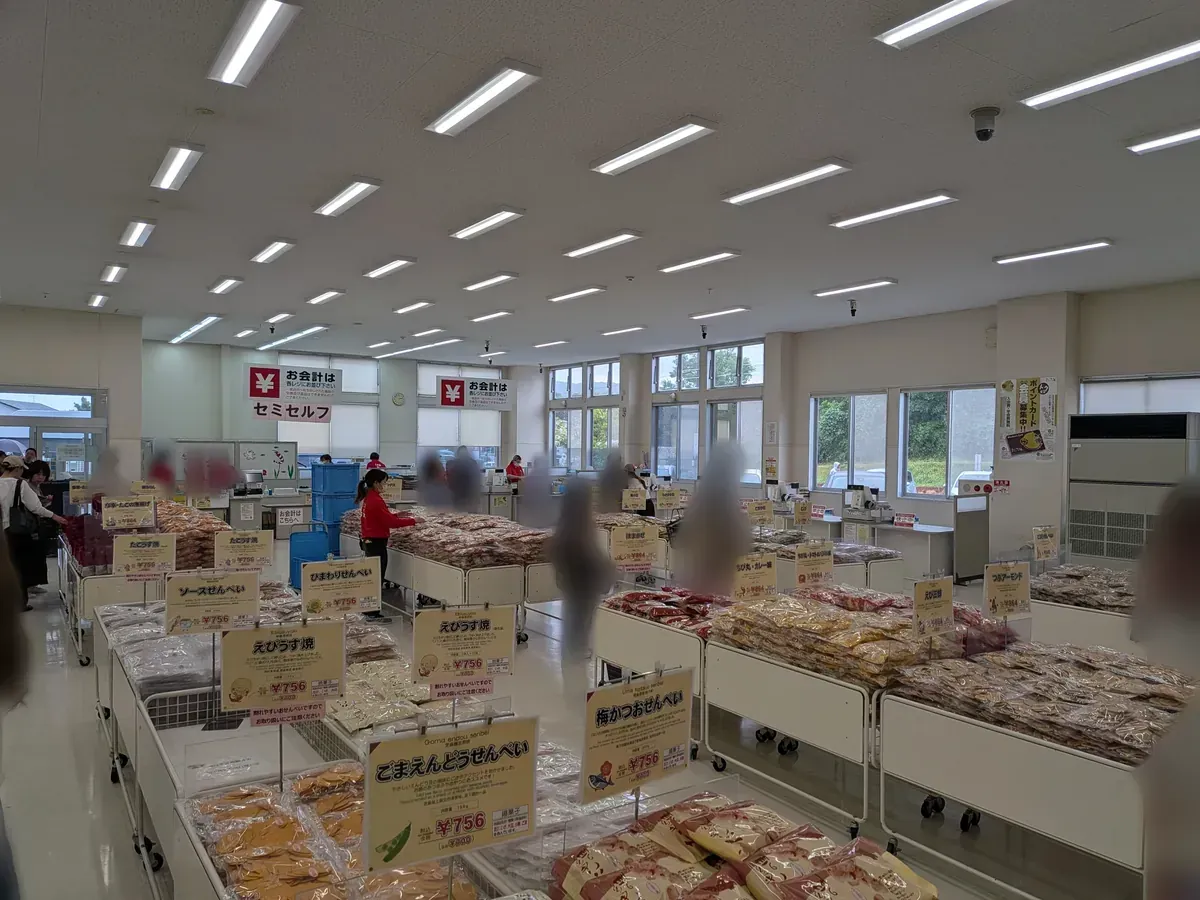 たこせんべいの里の店内フロア。せんべいが平台にずらりと並ぶ売り場の全景