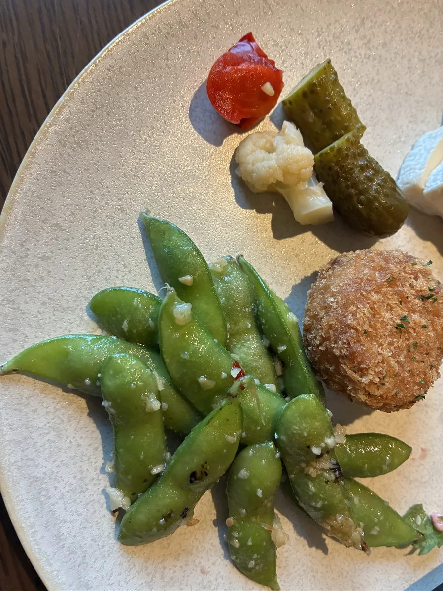 ラウンジの軽食プレート。枝豆やコロッケ、ピクルス、カリフラワーなどが彩りよく盛られている