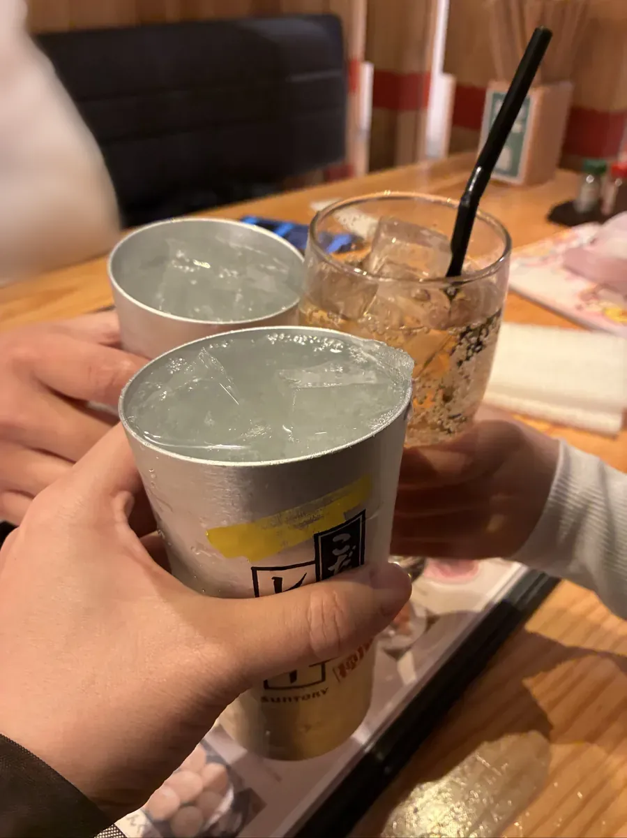 天満橋エリアの居酒屋でハイボールのジョッキを合わせて乾杯する手元