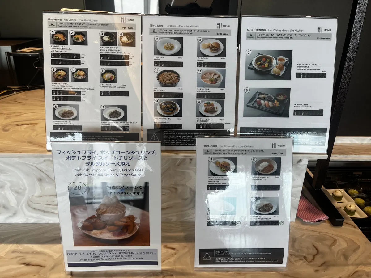 SUITE DININGの温かいお料理メニュー表。ビーフバーガー、ハンバーグ、カレー、ムール貝など約20種がカロリー付きで並ぶ。