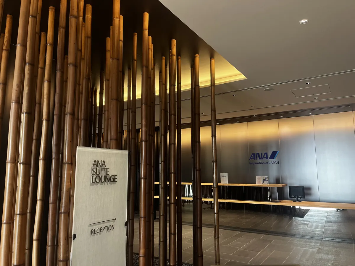 ANAスイートラウンジ羽田国際線の受付。竹を敷き詰めた和の意匠とANAロゴ、RECEPTIONの案内サイン。
