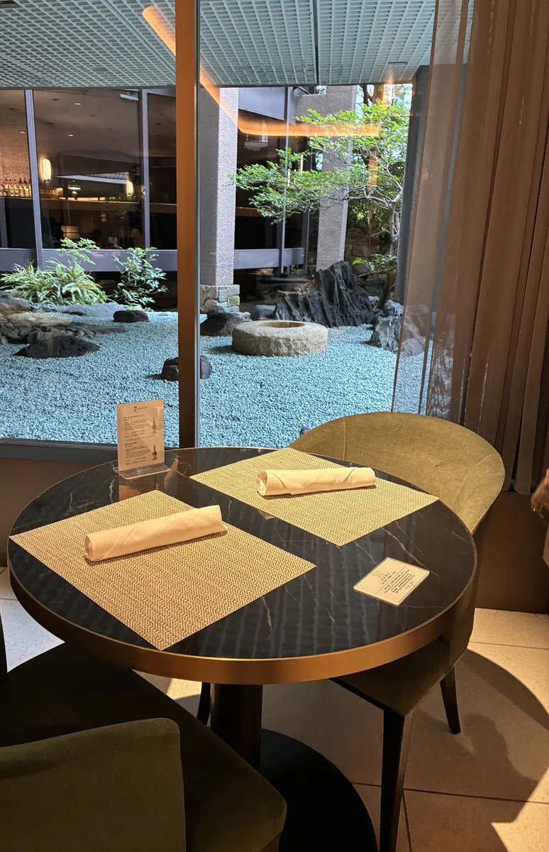 リーガロイヤルホテル大阪 リモネの朝食会場。坪庭（中庭）が見える窓際のテーブル席、朝の光が差し込む和モダンな空間
