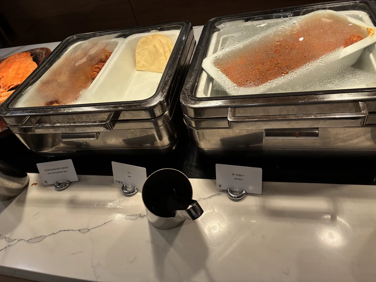 リモネ朝食のオリジナル朝カレーコーナー。ダールカレー、ジャガイモとカリフラワーのサブジ、ナン、隣にベイクドサーモン