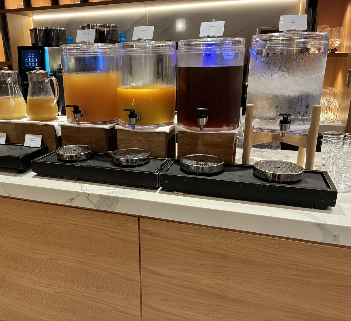 リモネ朝食のジュースディスペンサー。アップル・オレンジジュース、烏龍茶、水、グリーンスムージー
