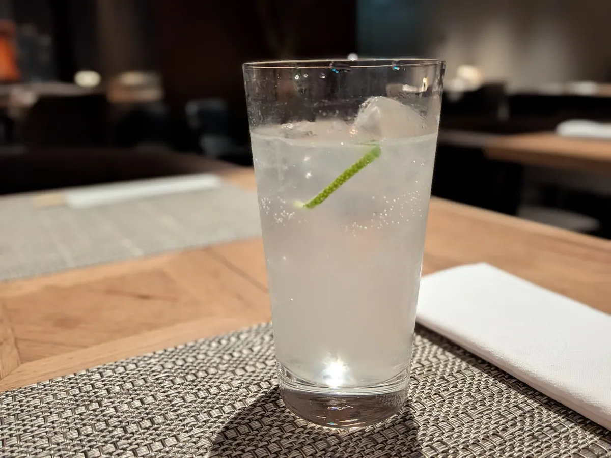 ロイヤルラウンジで提供されたスパークリング系のロングドリンク。ライムを添えた炭酸のグラス