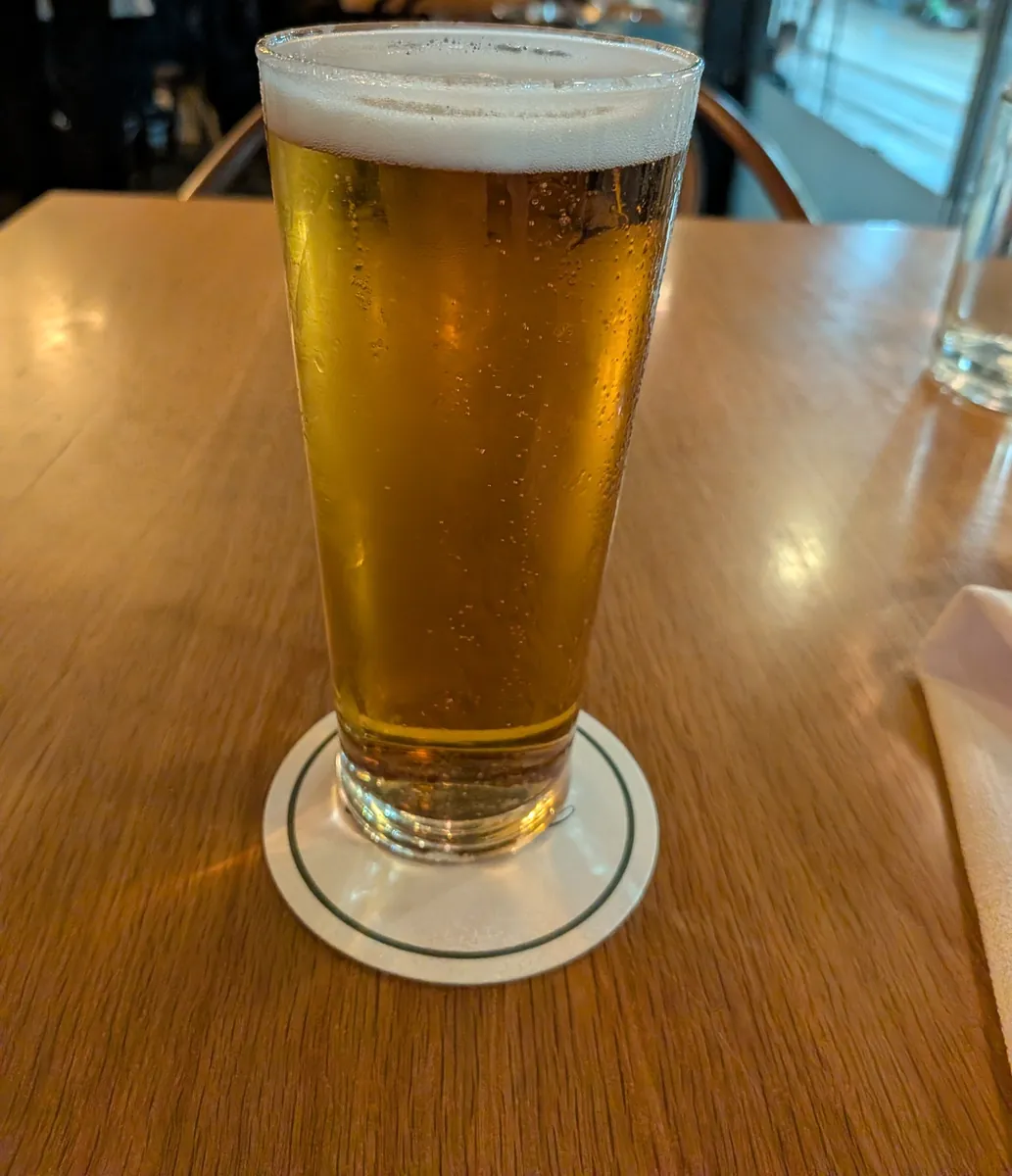 コースターに置かれたGreat Northern Super Crispのスクーナー。細長いグラスに黄金色のビールと白い泡