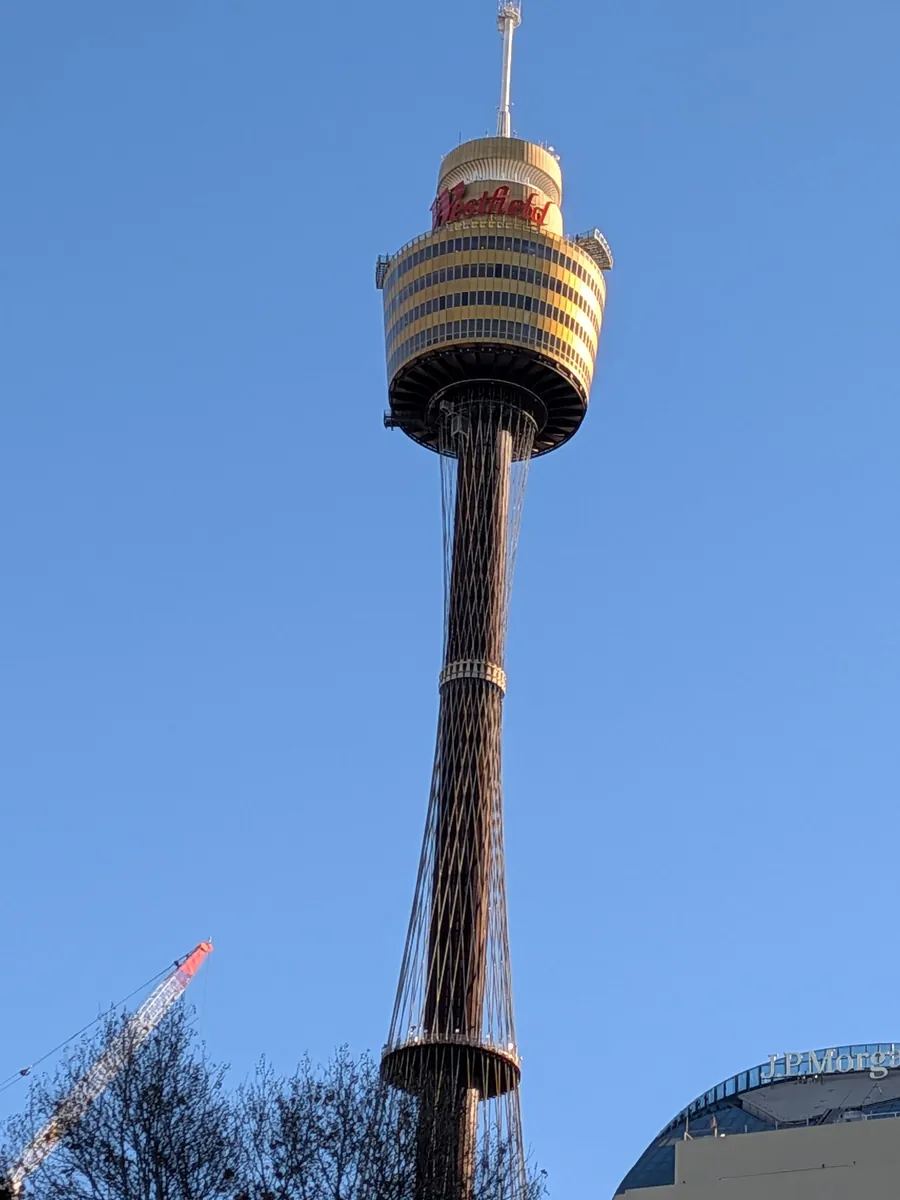 青空を背に立つシドニータワーの展望台部分のクローズアップ
