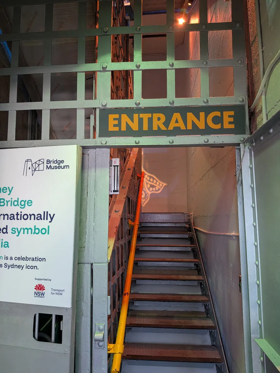 BridgeMuseumのENTRANCE看板と、鉄骨がむき出しの急な階段