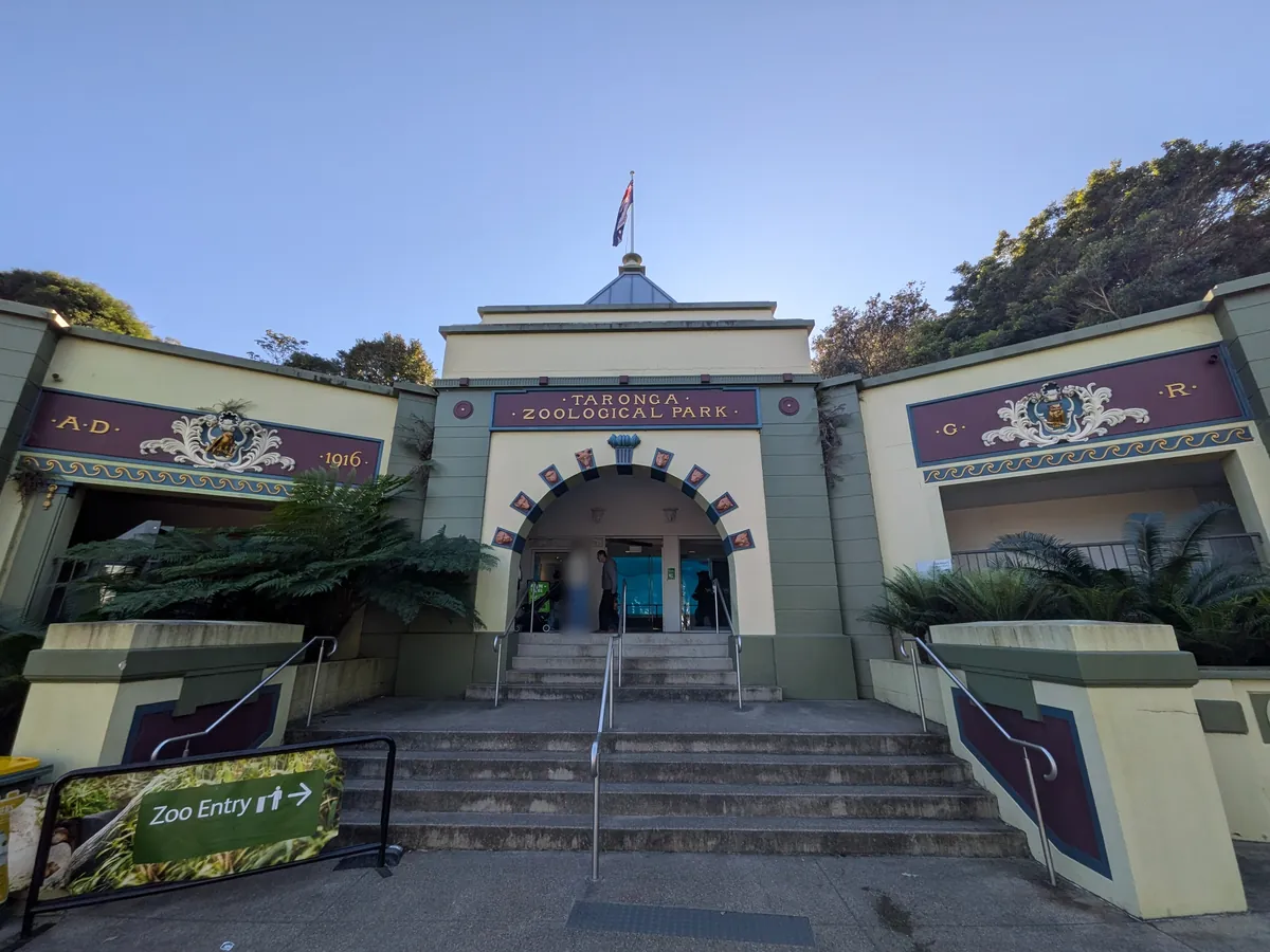 タロンガ動物園の正門。装飾された門柱と階段、Zoo Entry の案内