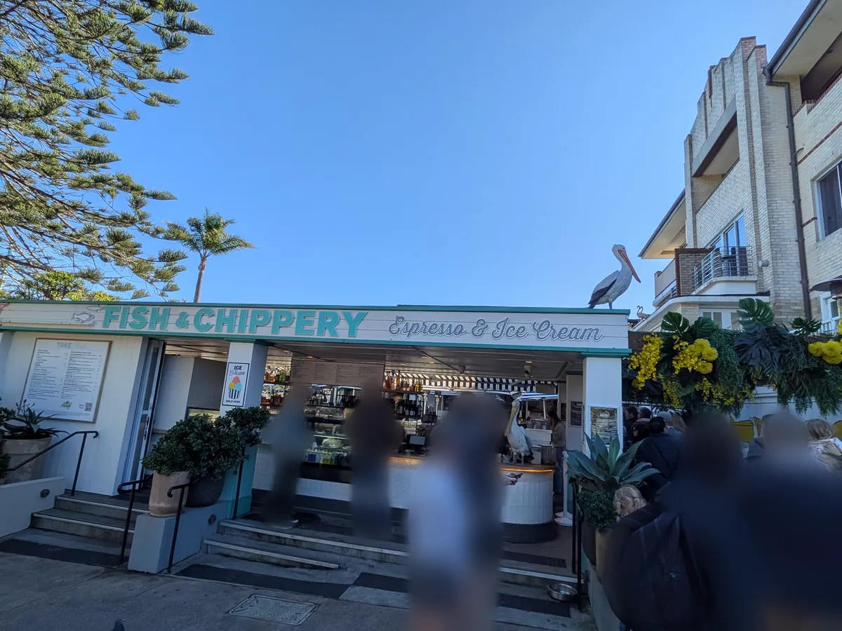 FISH & CHIPPERY の店先。Corona & Ice Cream の表示と観葉植物
