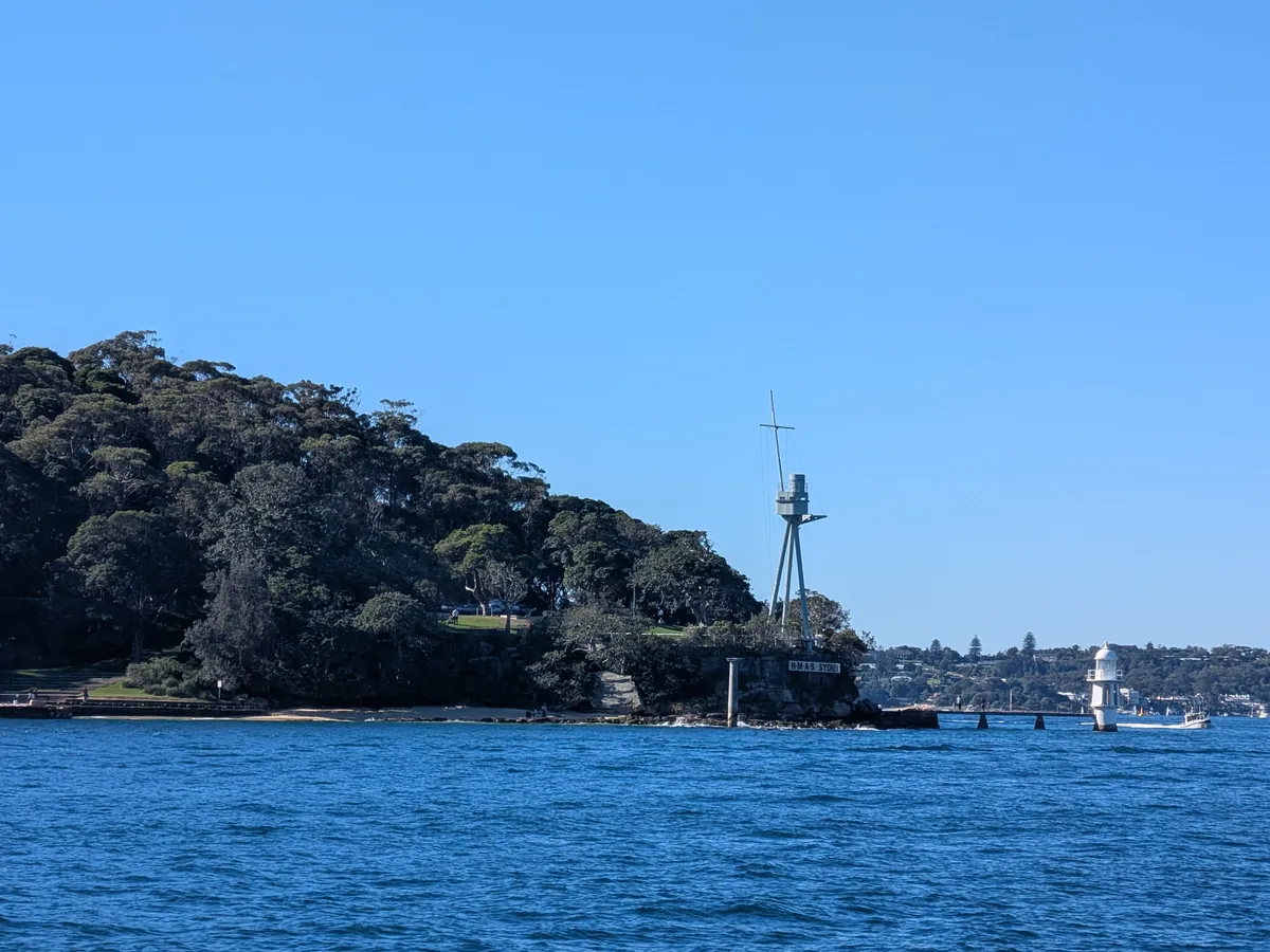 湾の対岸の岬。木立の中に細いマストが立っているのが見える