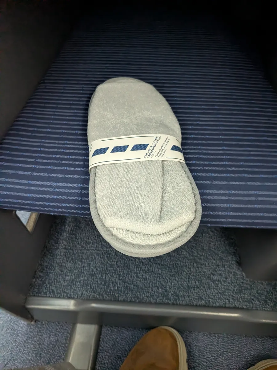 ビジネスクラスのふかふかのグレーのスリッパ