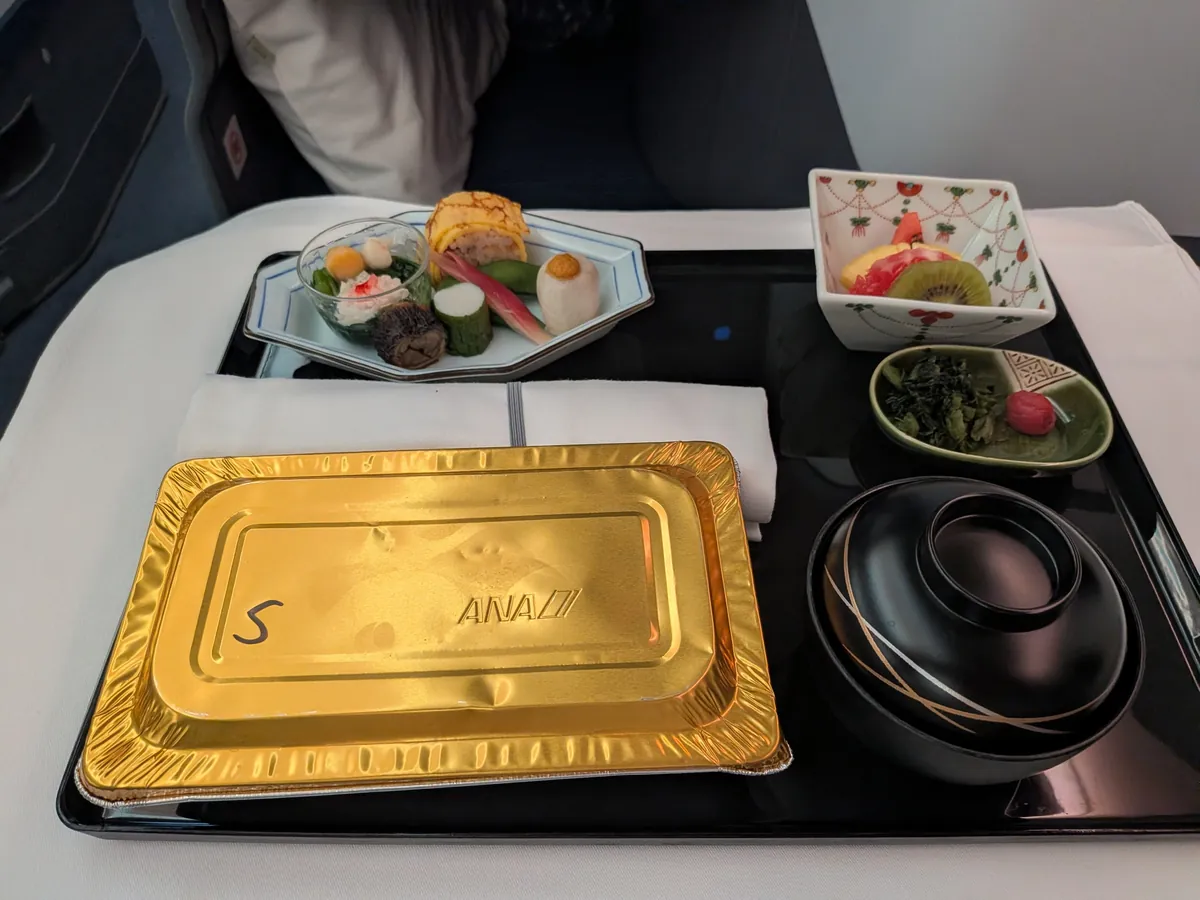 往路の和食御膳の全体。金の紙で覆われた主菜と前菜・味噌汁・香の物