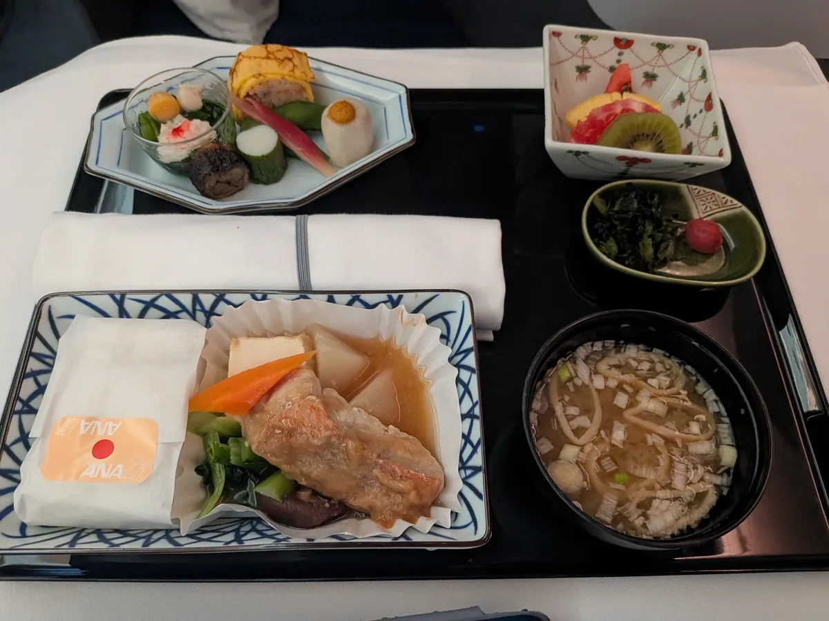 往路の和食。主菜の金目鯛仙台味噌煮、前菜の八寸、フルーツ、味噌汁の御膳