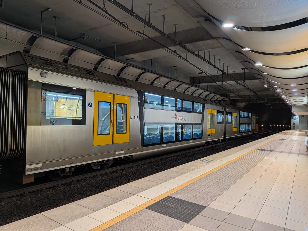 シドニー・トレインズの二階建て車両が国際空港駅のホームに停車している