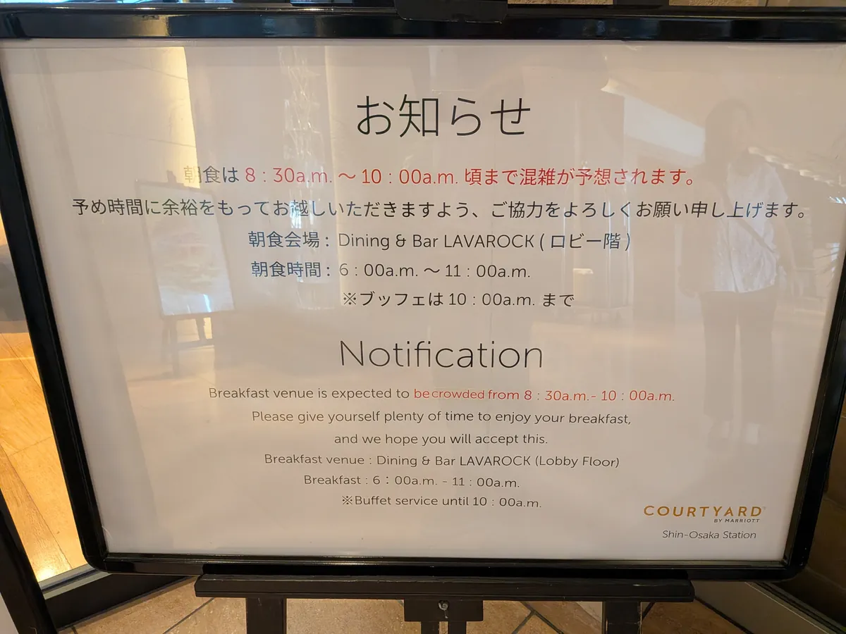 朝食会場入口のお知らせ看板。混雑予想時間8:30-10:00と朝食時間6:00-11:00が案内されている