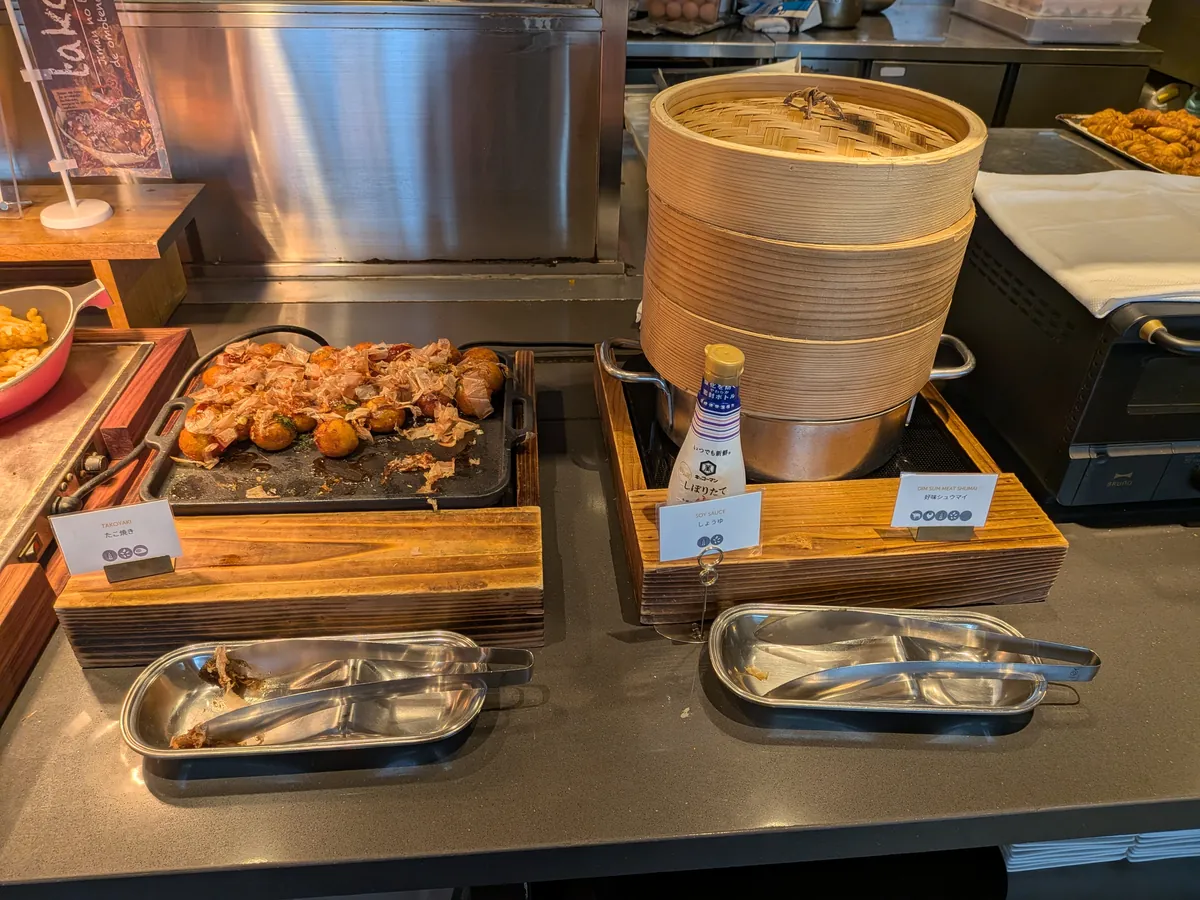 串に刺した焼き物と蒸籠が置かれた朝食のホットコーナー