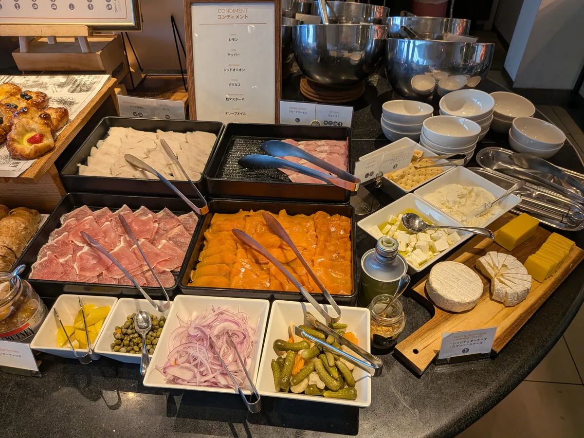 朝食のコールドミールコーナー。生ハムとスモークサーモン、チーズ、ピクルスが並ぶ