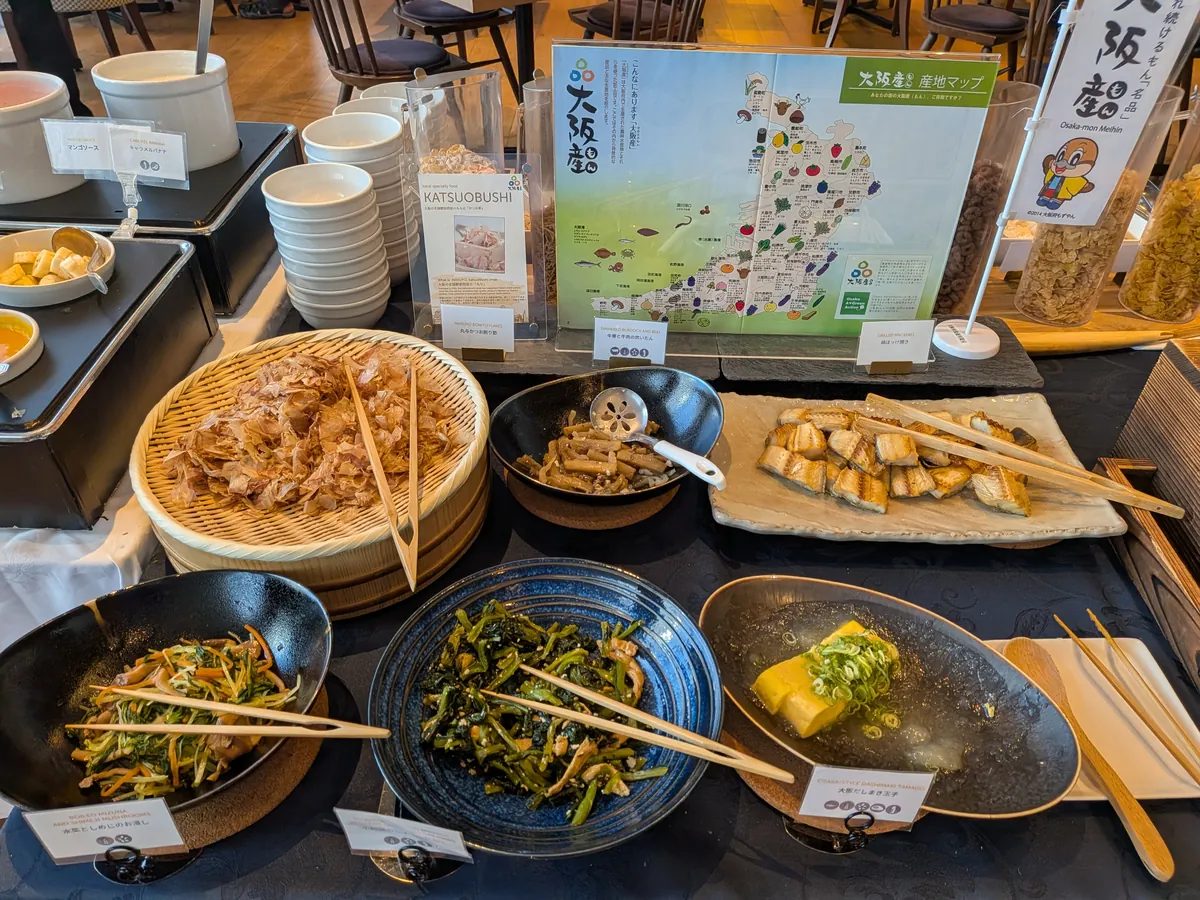 「大阪産」の旗が立つ地元食材の総菜コーナー。青菜のおひたしや串の練り物、出汁巻き玉子が並ぶ