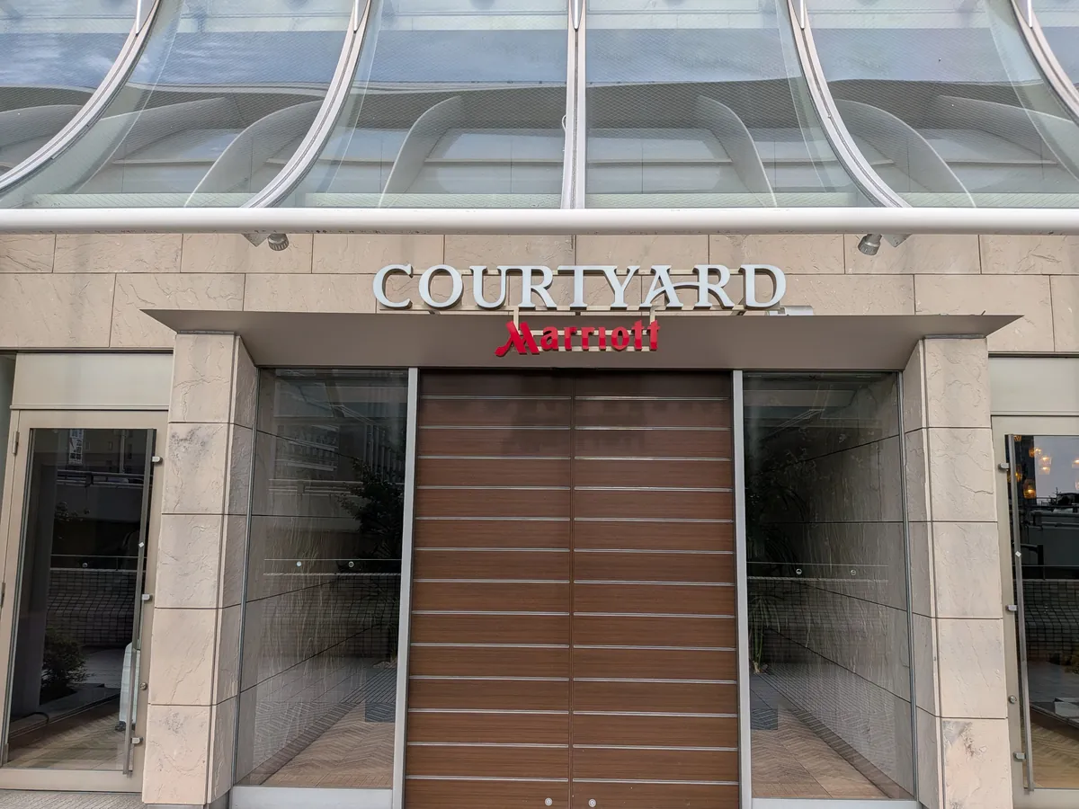 ホテルのエントランス。ガラス屋根の下にCOURTYARD Marriottのサインが掲げられている