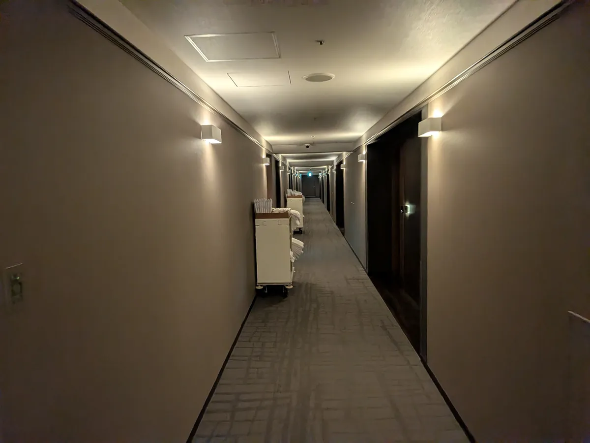 客室階の廊下。照明を落とした落ち着いたトーンで奥まで続く
