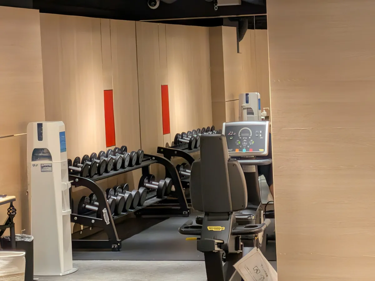 フィットネスセンターの内部。ダンベルラックとトレーニングマシンが並ぶ