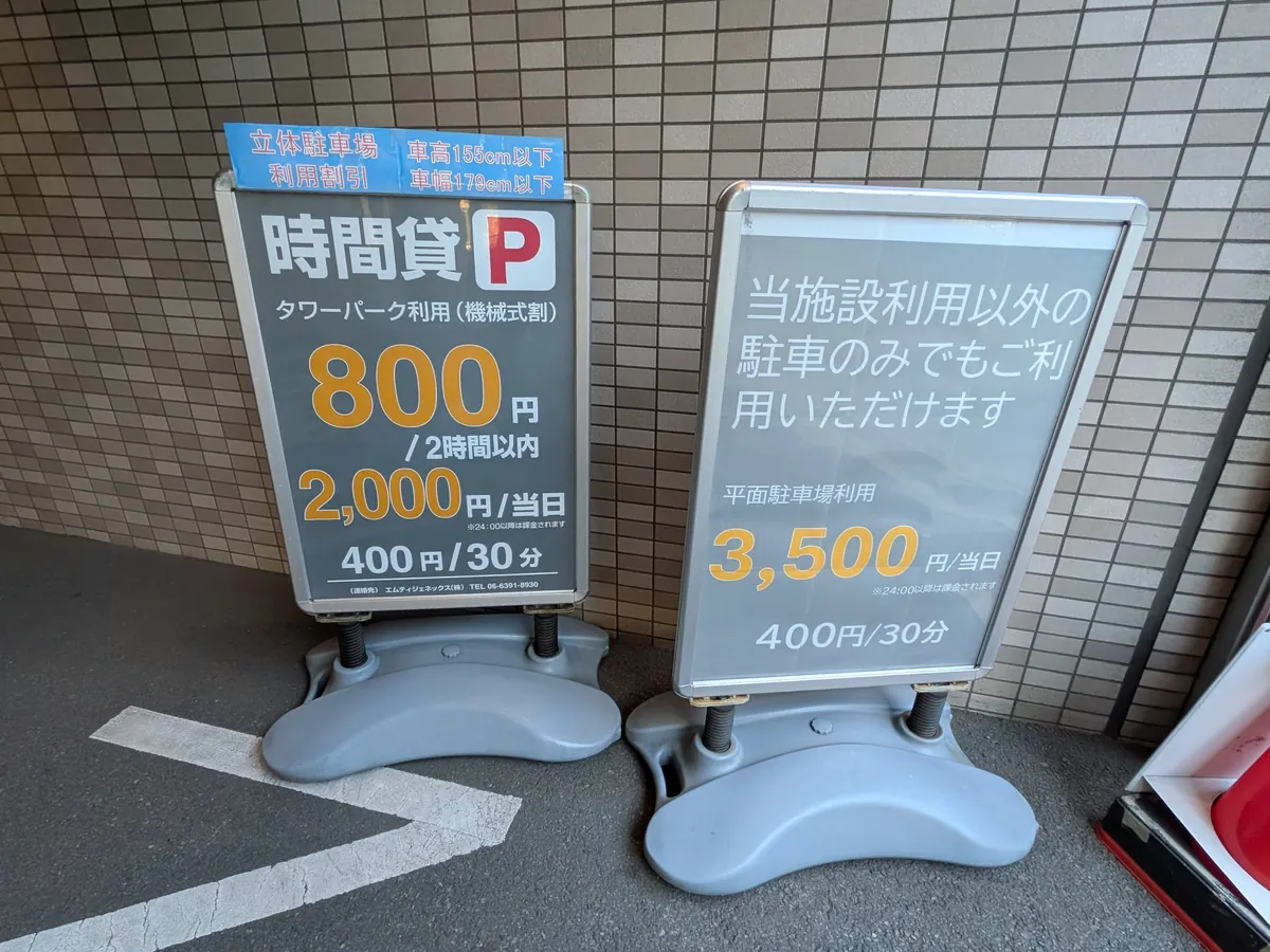 駐車場の料金看板。時間貸と当日最大料金が表示されている