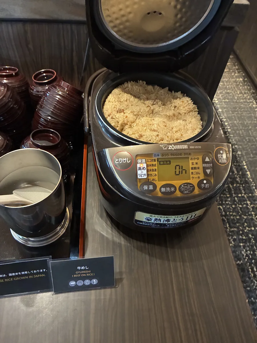 ラウンジのカクテルタイムに置かれた牛めしの炊飯器と塗りのお椀