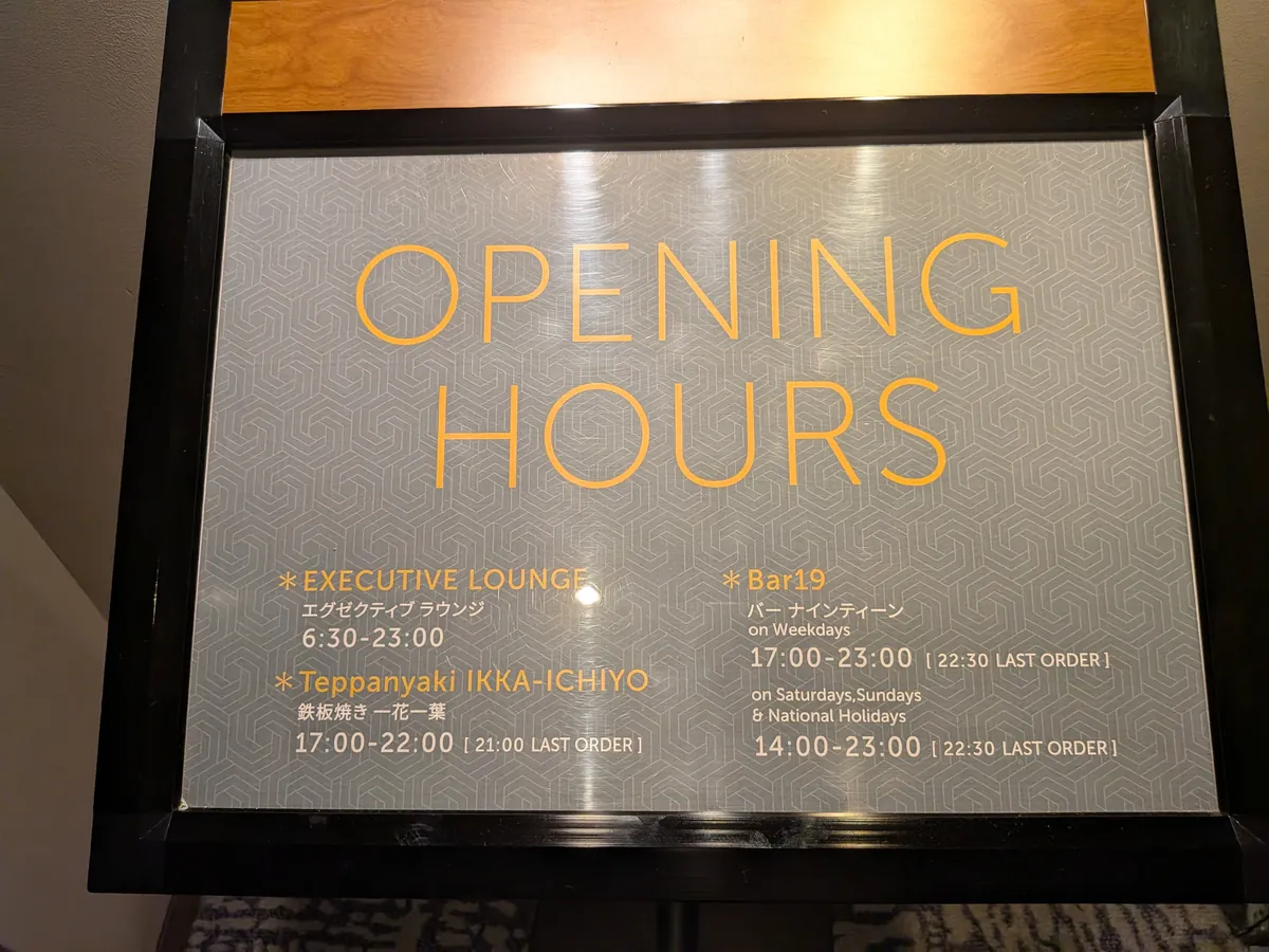 OPENING HOURSの案内板。エグゼクティブラウンジ6:30-23:00、鉄板焼き一花一葉、Bar19の営業時間