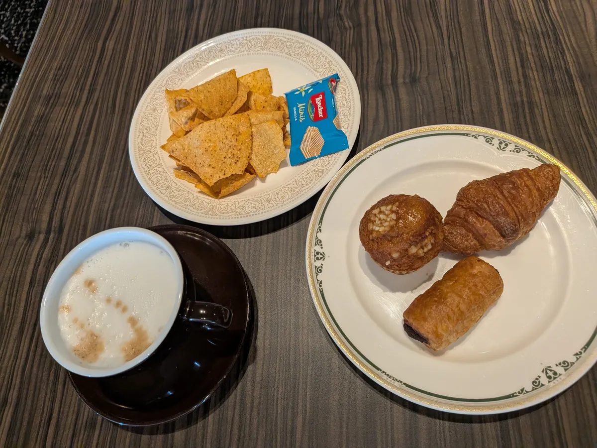 ティータイムに取り分けたクロワッサンとマフィン、カフェラテとチップスの皿